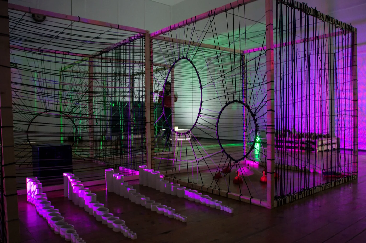 Installation de fils et de cerceaux éclairés en violet et vert